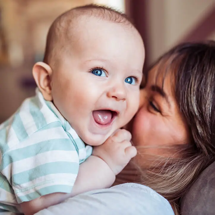 Mutter kuschelt mit lachendem Baby