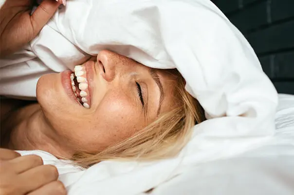 Frau liegt im Bett